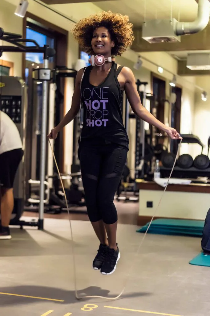 Marie Amière springt mit Kopfhörern um den Hals im Fitnessstudio Aspria Uhlenhorst Seil.