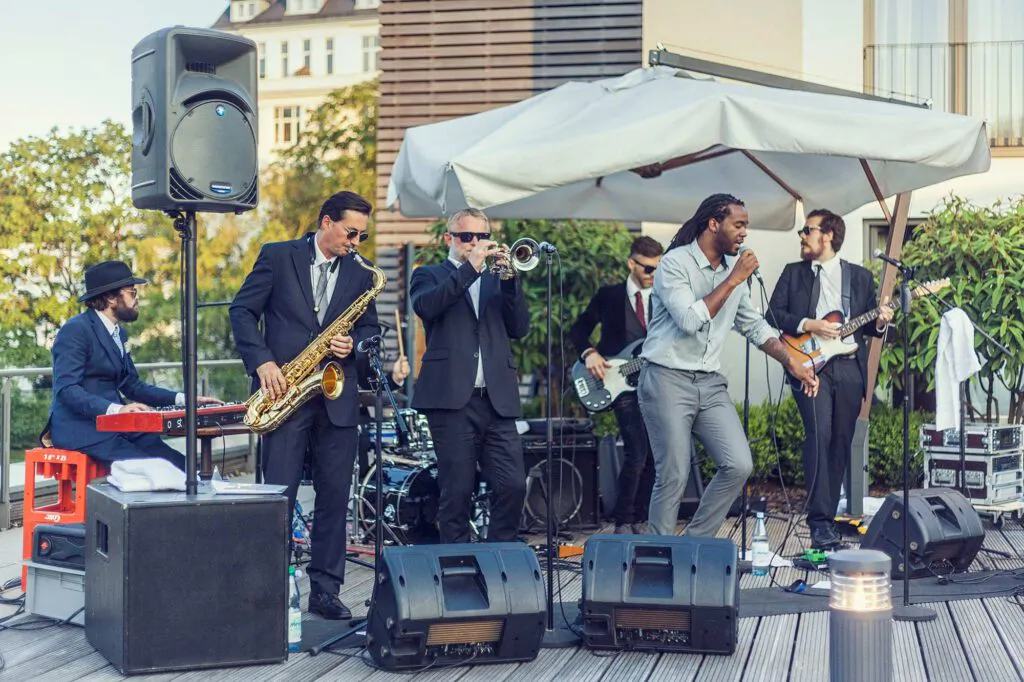 Baba Soul & the Professors of Funk spielen bei Tageslicht auf einer Terrasse mit Sänger, Bläsern und Keyboard.