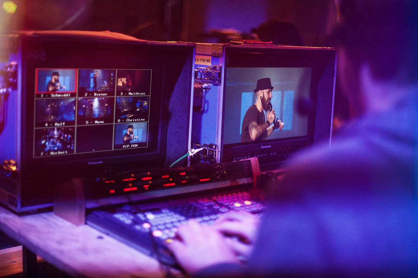 Person am beleuchteten Videomischpult, zwei Monitore zeigen Bühnenaufnahmen beim NDR Comedy Contest.